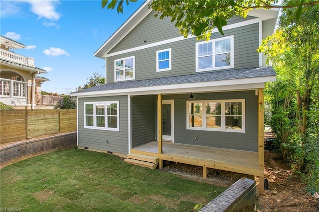 rear view of property featuring crawl space, a yard, roof with shingles, and fence