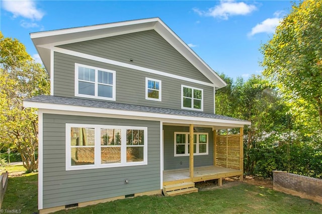 back of property featuring a shingled roof, a porch, a yard, and crawl space