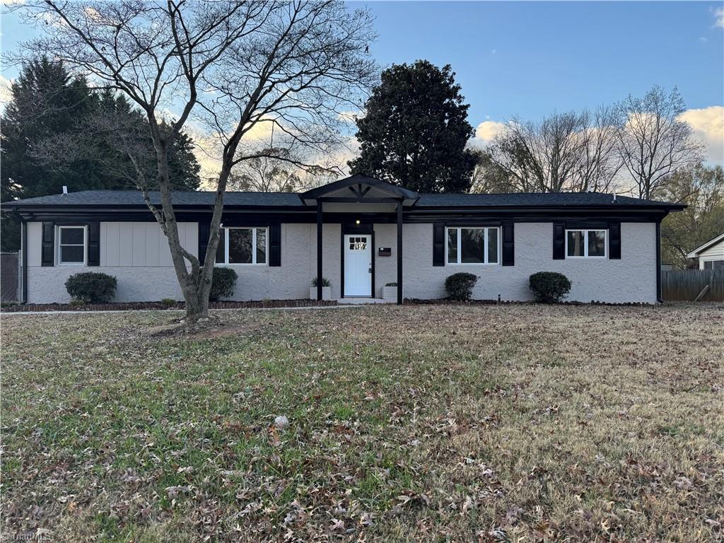 single story home featuring a lawn