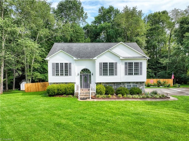 raised ranch featuring a storage shed and a front yard