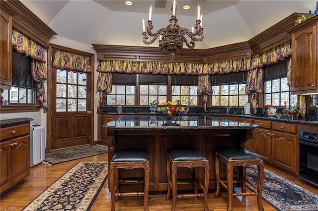 6 Curtis Ct, Thomasville, NC 27360 - bar area featuring vaulted ceiling, black oven, a chandelier, light wood-style flooring, and radiator heating unit
