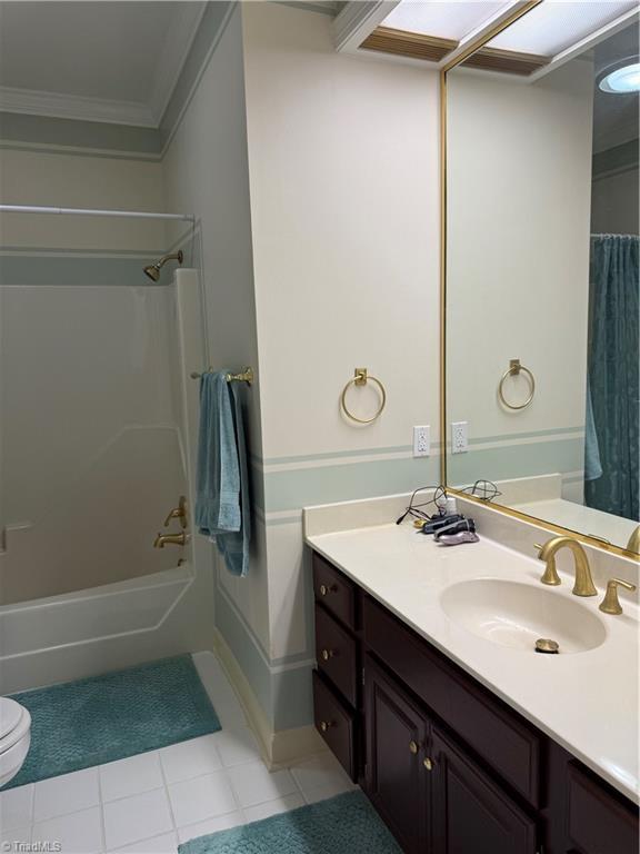 1223 Gatehouse Rd, High Point, NC 27262 - bathroom featuring crown molding, vanity, tile patterned floors, shower / bathtub combination with curtain, and toilet