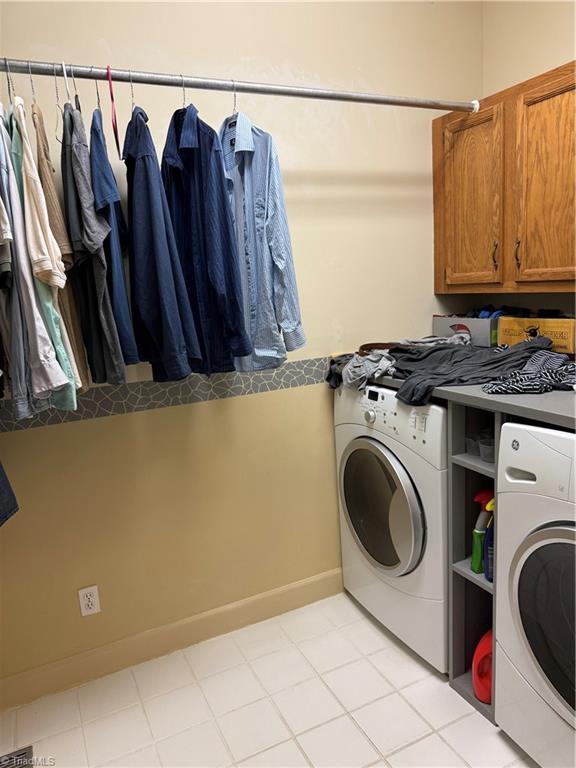 1223 Gatehouse Rd, High Point, NC 27262 - washroom with cabinet space, washing machine and dryer, and baseboards