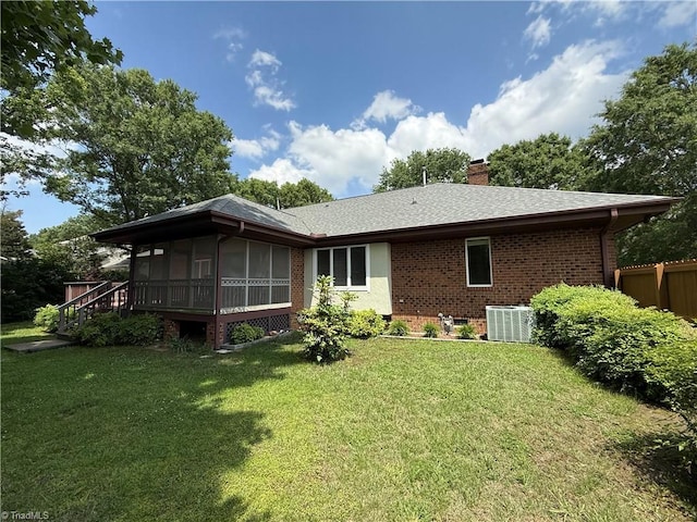 1223 Gatehouse Rd, High Point, NC 27262 - rear view of property featuring central air condition unit, a sunroom, brick siding, a chimney, and a yard