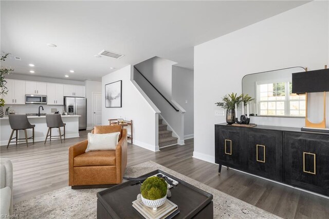 living room with dark wood-type flooring and sink