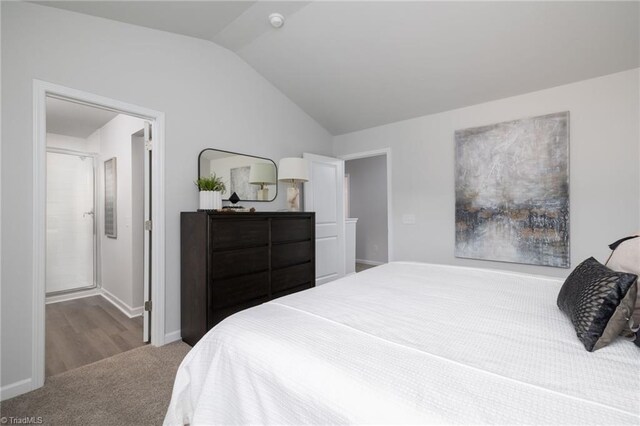 bedroom featuring light carpet and vaulted ceiling