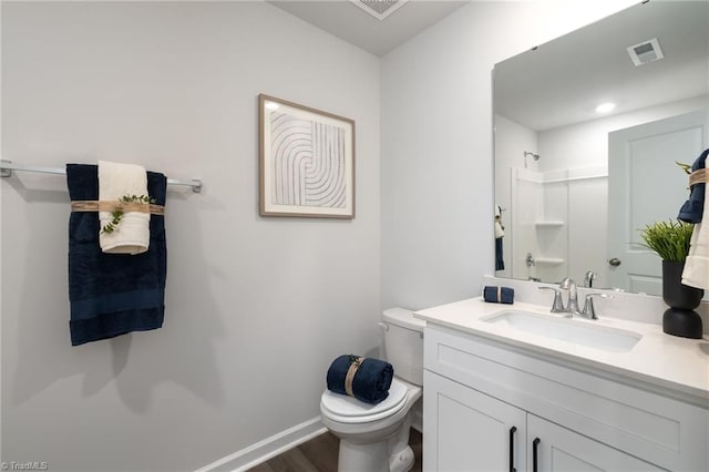 bathroom featuring toilet, wood-type flooring, vanity, and a shower