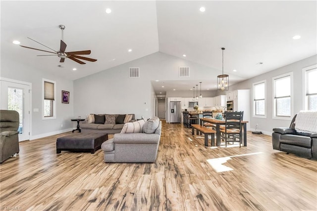 living room featuring ceiling fan, light hardwood / wood-style flooring, and lofted ceiling