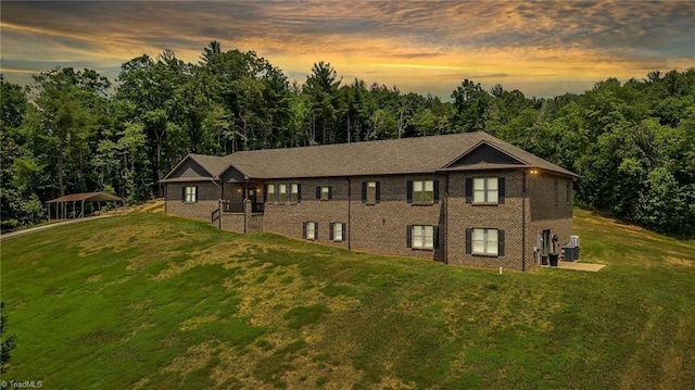 view of front of property with a yard and central AC unit