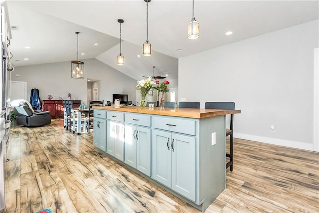 kitchen featuring pendant lighting, lofted ceiling, light hardwood / wood-style floors, and butcher block counters