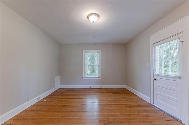 unfurnished room with baseboards and light wood-type flooring