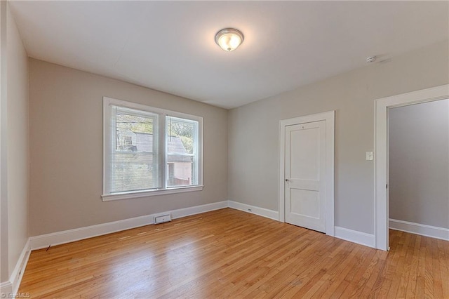 unfurnished room with baseboards and light wood-style floors