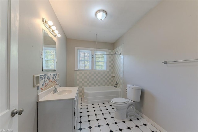 bathroom featuring baseboards, bathing tub / shower combination, vanity, and toilet