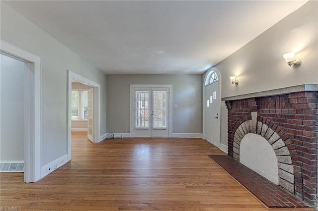 unfurnished living room with baseboards, wood finished floors, and visible vents