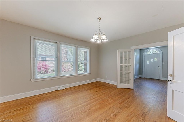 interior space with baseboards, visible vents, a chandelier, and light wood finished floors