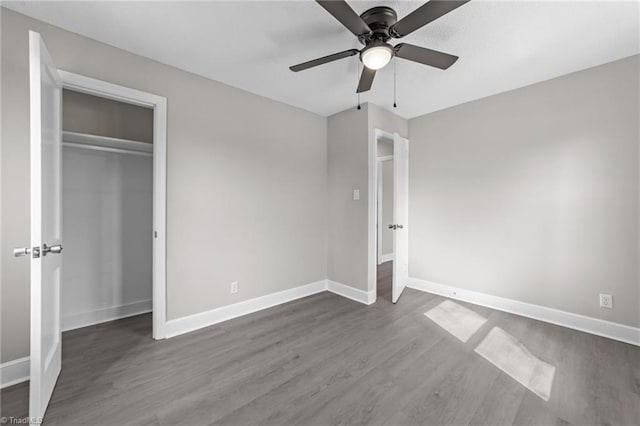 unfurnished bedroom with a ceiling fan, baseboards, and wood finished floors