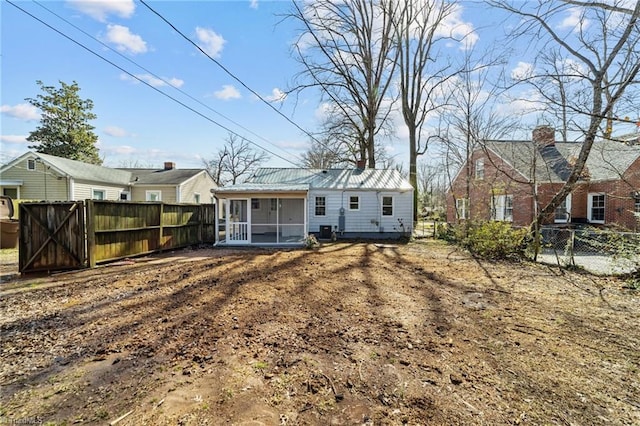 rear view of house featuring a sunroom, a fenced backyard, and metal roof