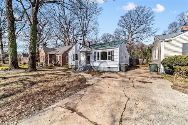 view of front facade with a residential view, crawl space, driveway, and metal roof