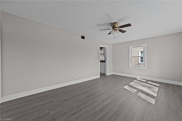 spare room featuring a ceiling fan, dark wood finished floors, a textured ceiling, and baseboards