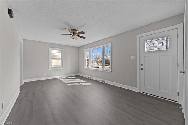 foyer entrance with dark wood-style flooring, visible vents, ceiling fan, and baseboards