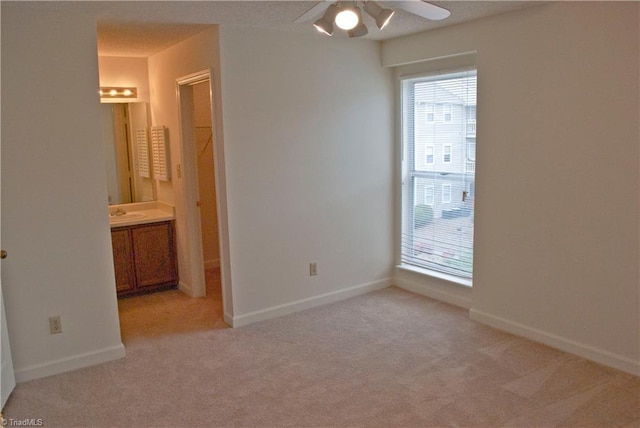 carpeted empty room with ceiling fan and sink