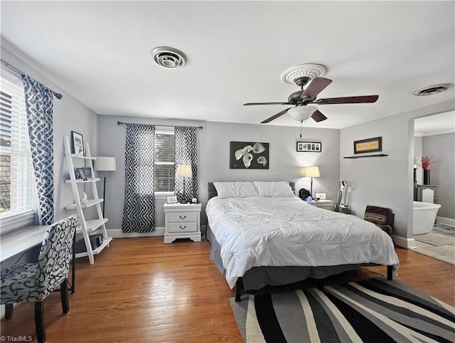 bedroom featuring baseboards, a ceiling fan, wood finished floors, and visible vents