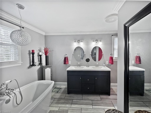 full bathroom with plenty of natural light, double vanity, a freestanding tub, and ornamental molding