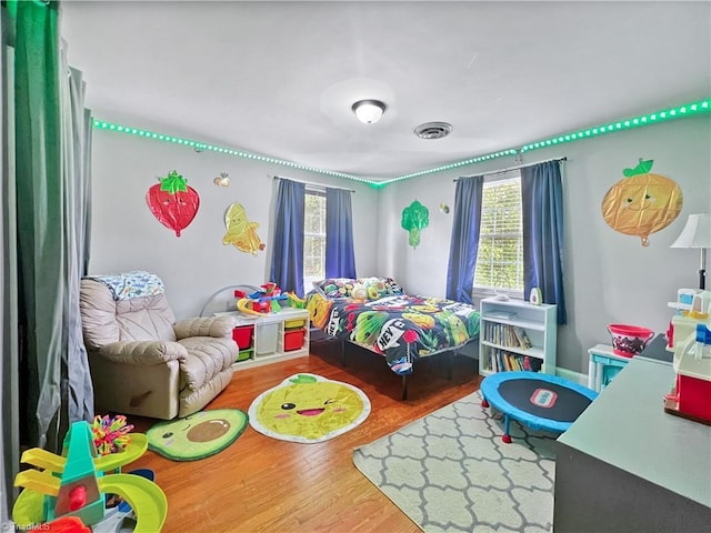 bedroom featuring visible vents and wood finished floors
