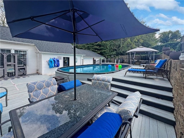 view of swimming pool with a fenced in pool, outdoor dining area, a deck, and a gazebo