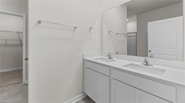 3822 Colt Ct, Trinity, NC 27370 - full bath with double vanity, a walk in closet, and baseboards