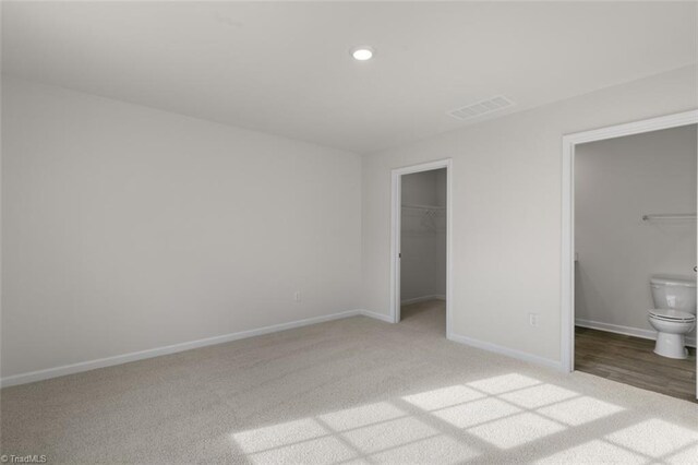 152 E Farm Loop, Stokesdale, NC 27537 - unfurnished bedroom featuring visible vents, a walk in closet, recessed lighting, carpet floors, and baseboards