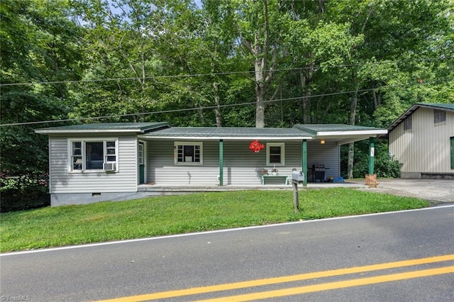 view of front of house with a carport, covered porch, and a front yard