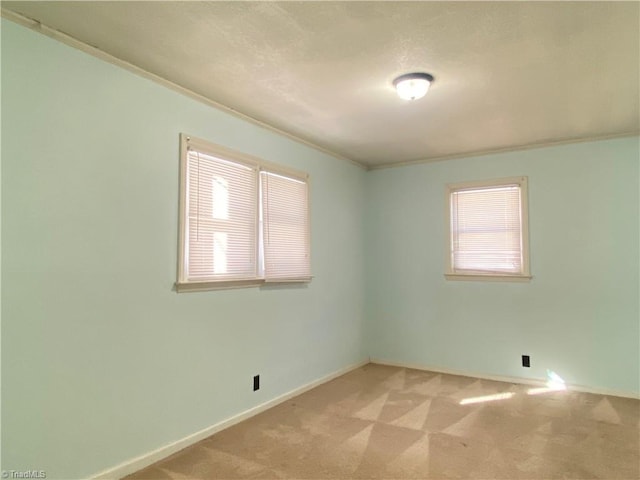 unfurnished room with light colored carpet and crown molding