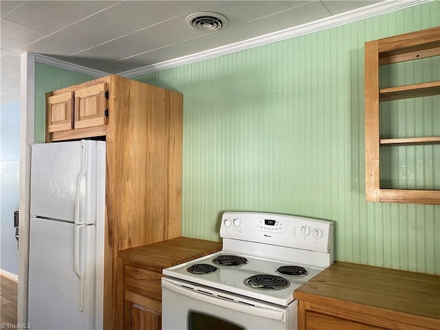 kitchen featuring wood walls, white appliances, and ornamental molding