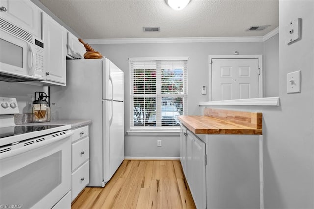 kitchen with crown molding, white appliances, wood counters, white cabinets, and light hardwood / wood-style flooring