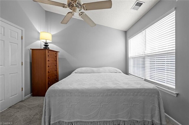 carpeted bedroom with ceiling fan and vaulted ceiling