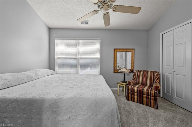 bedroom with a textured ceiling, a closet, ceiling fan, and carpet floors