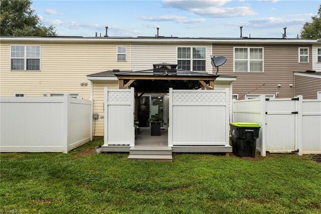 rear view of house featuring a lawn