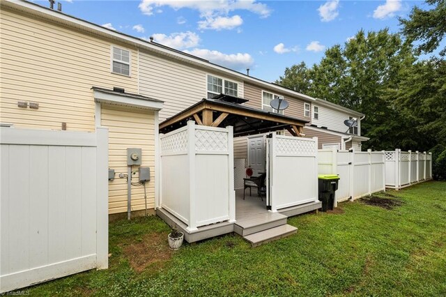 rear view of property with a yard