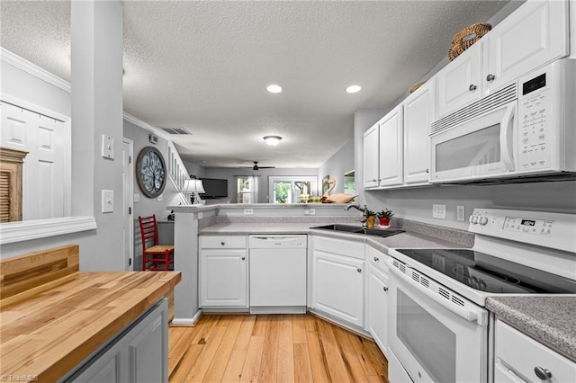 kitchen with white appliances, light wood-type flooring, crown molding, ceiling fan, and white cabinets