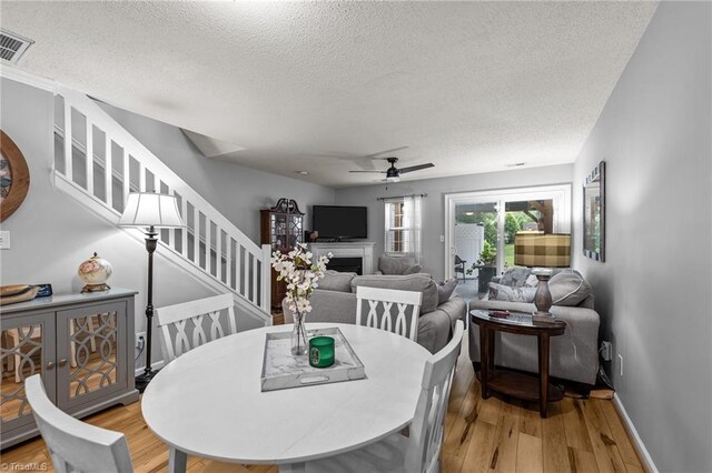 dining space featuring ceiling fan, a textured ceiling, and light hardwood / wood-style floors