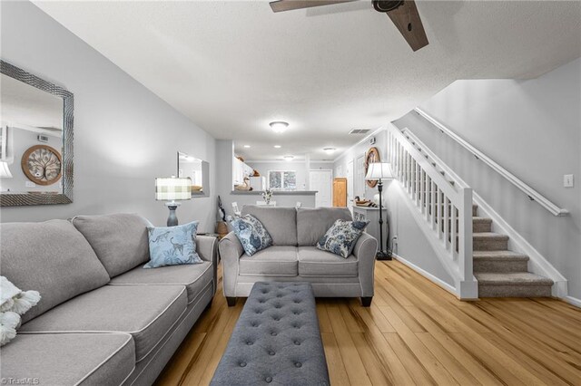 living room with ceiling fan and light wood-type flooring