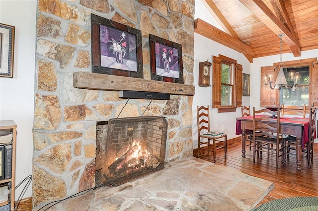 dining room featuring wood ceiling, lofted ceiling with beams, a stone fireplace, hardwood / wood-style flooring, and a notable chandelier