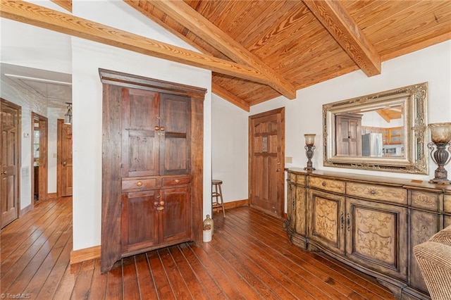 hall featuring lofted ceiling with beams, baseboards, dark wood-style flooring, and wooden ceiling