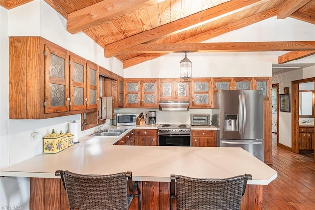 kitchen featuring lofted ceiling with beams, kitchen peninsula, appliances with stainless steel finishes, and dark hardwood / wood-style floors