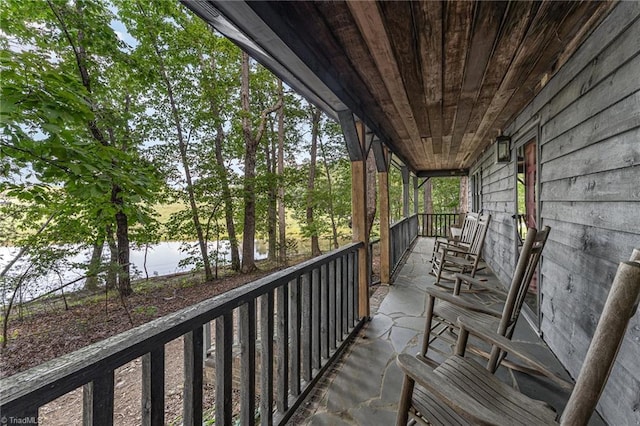 balcony featuring covered porch and a water view