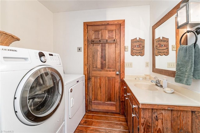 clothes washing area featuring washing machine and dryer, laundry area, dark wood-type flooring, and a sink