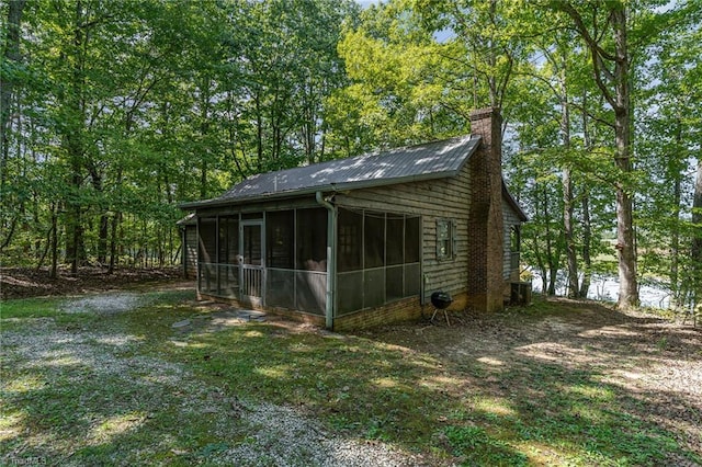 view of outdoor structure with central air condition unit and a sunroom