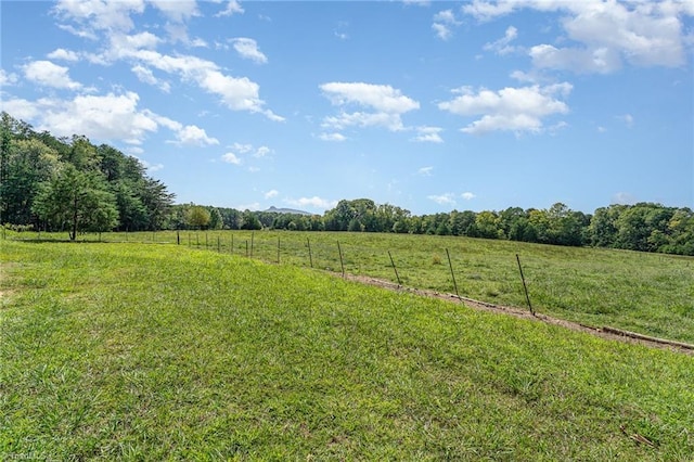 view of yard featuring fence and a rural view