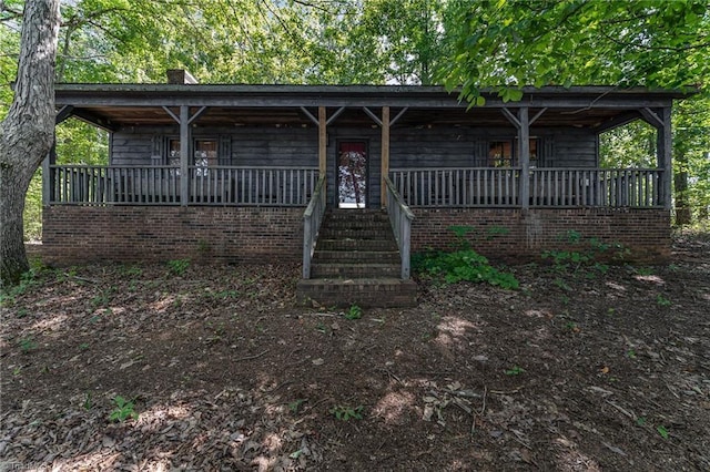 view of front facade with a chimney and a porch